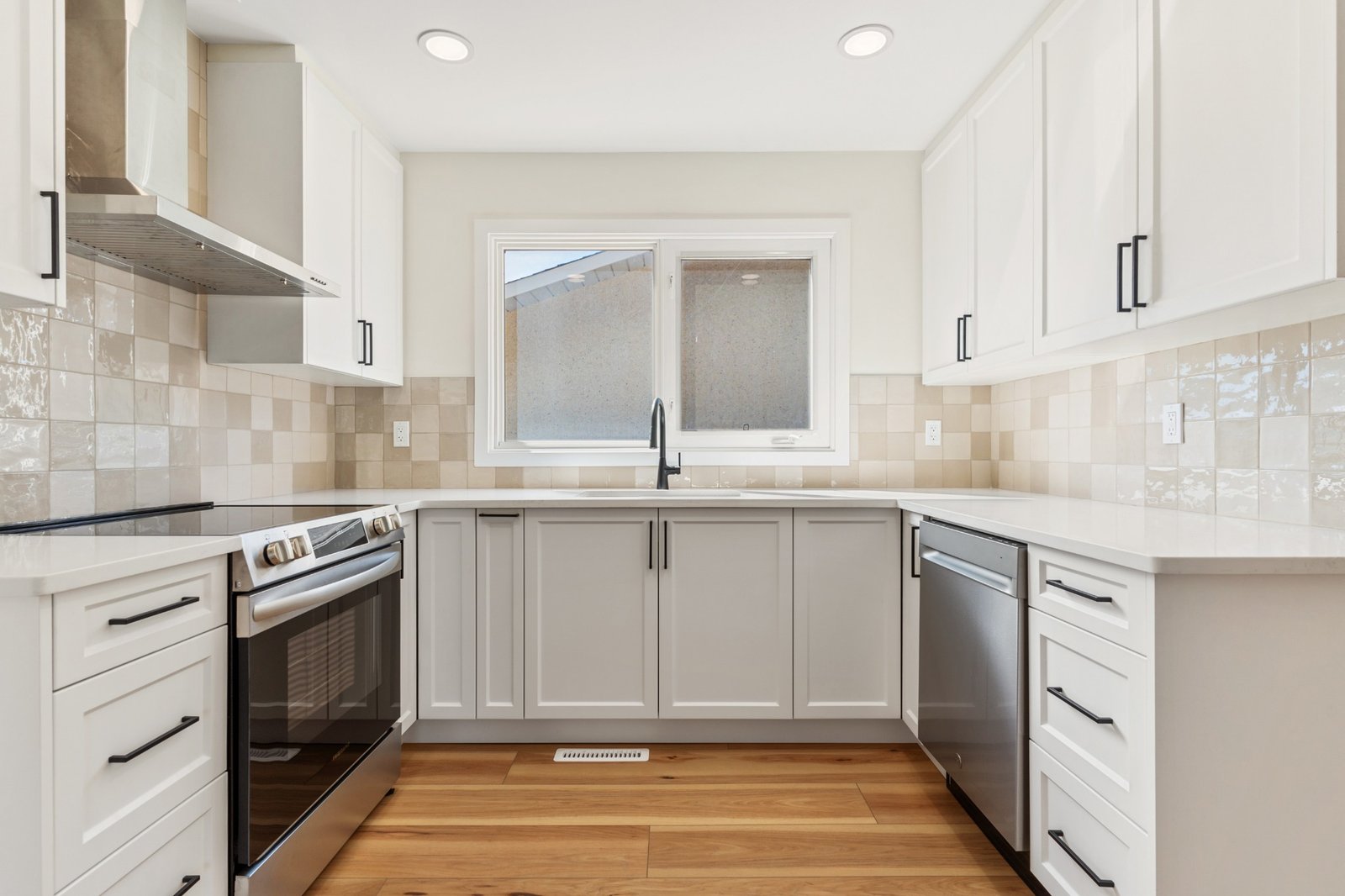 WestForge kitchen renovation with white cabinets, tile backsplash and black hardware