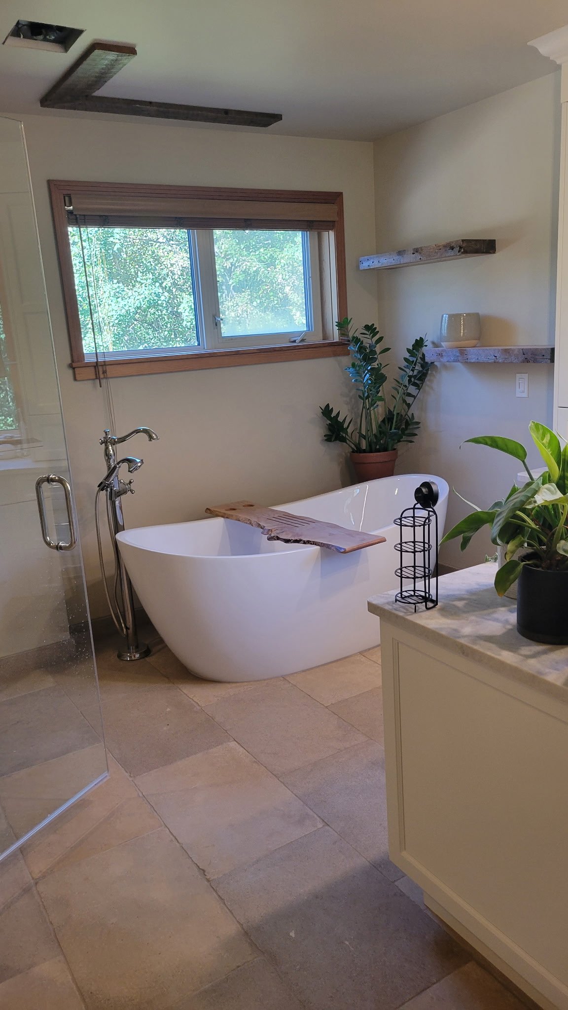 Freestanding bathtub with natural wood details in a WestForge bathroom renovation