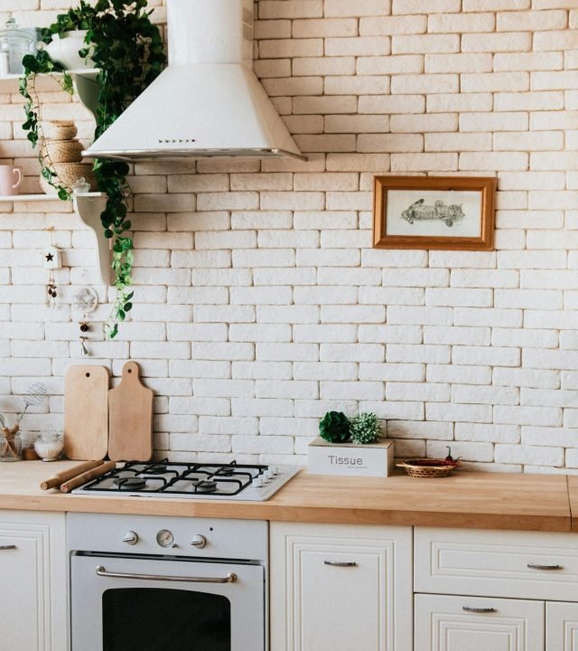Stylish kitchen interior with modern appliances, wooden counters, and greenery accents.